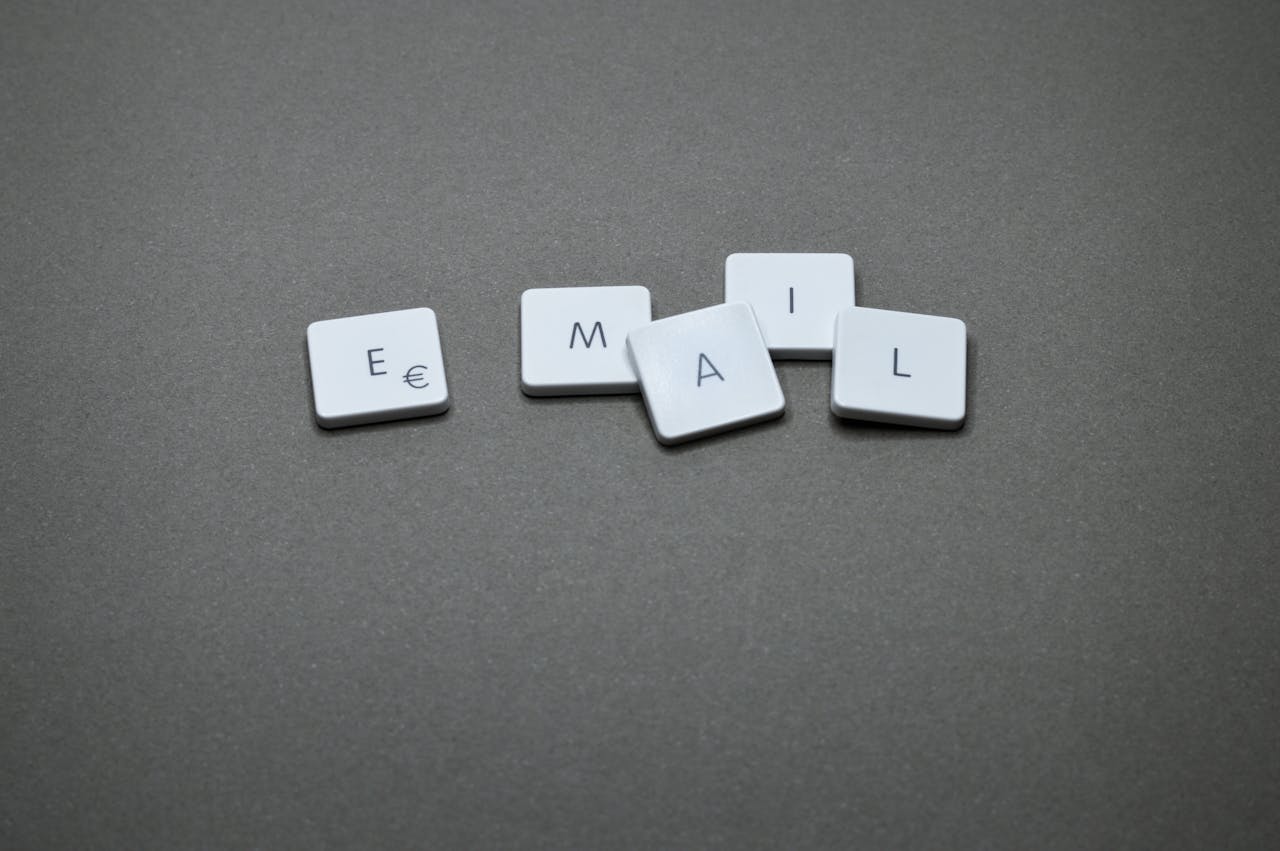 Close-up of the word email formed with letter tiles on a gray surface.